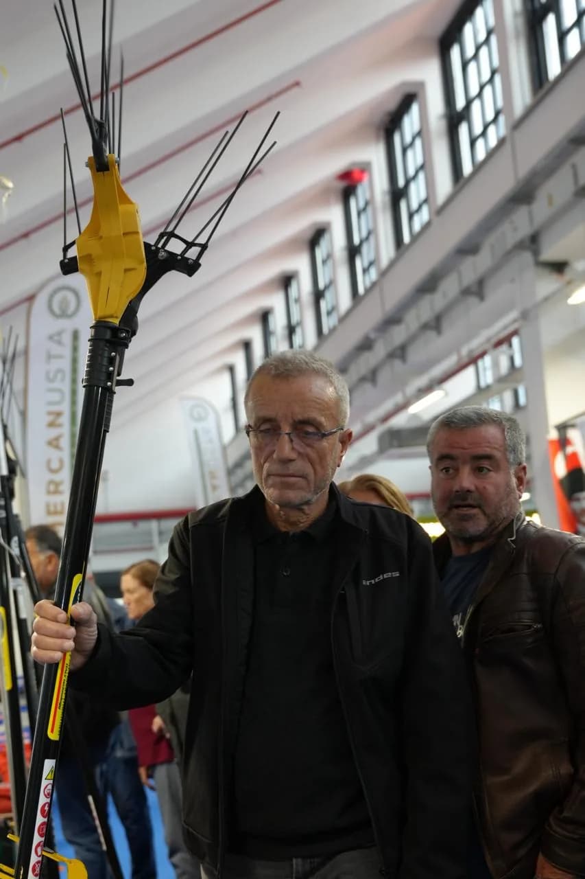 Uzun saplı budama makasını inceleyen iki ziyaretçi